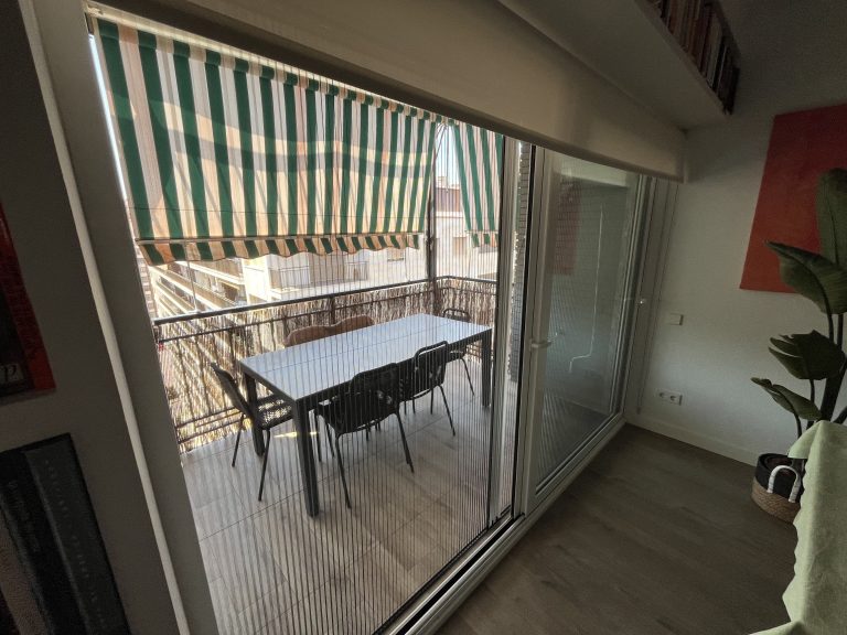 Mosquitera plisada para puerta instalada en vivienda de Valencia