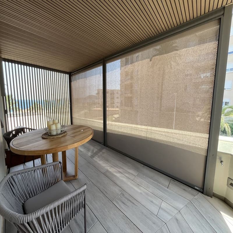 Protección solar vertical parcialmente bajada en una terraza con mesa